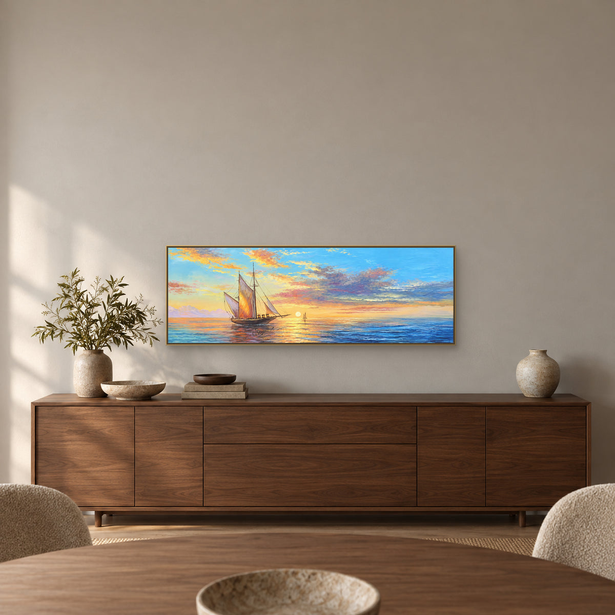 Sunset sailboat painting with a champagne-tone frame above a walnut dining-room sideboard