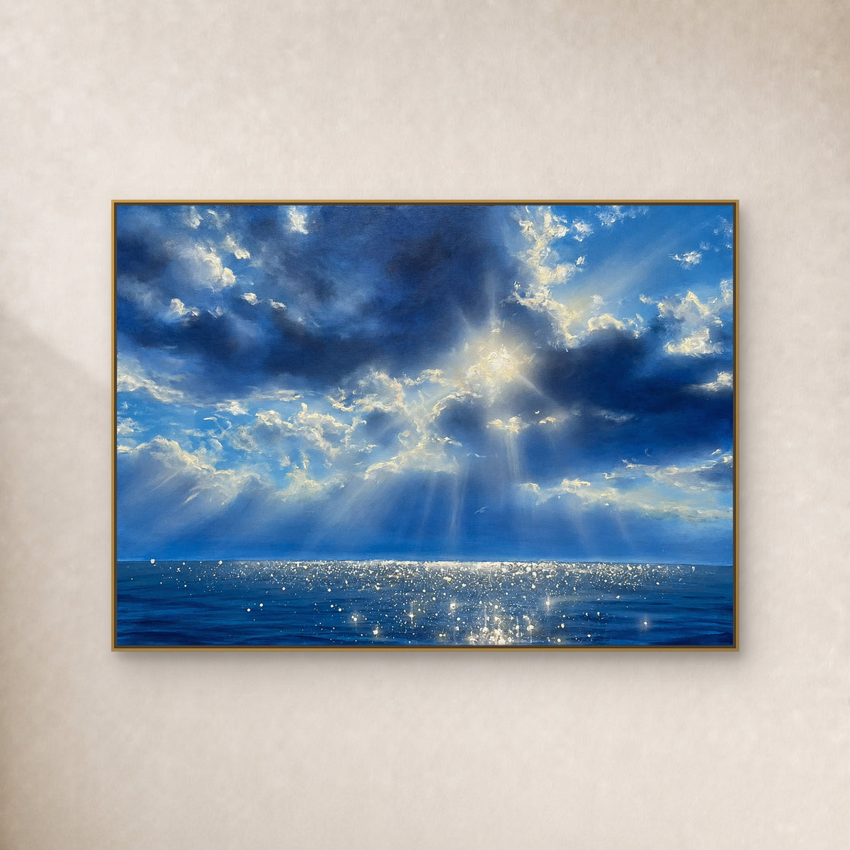 Paysage marin aux nuages bleus, rayons de soleil et reflets argentés, dans un fin cadre flottant doré sur un mur ivoire.