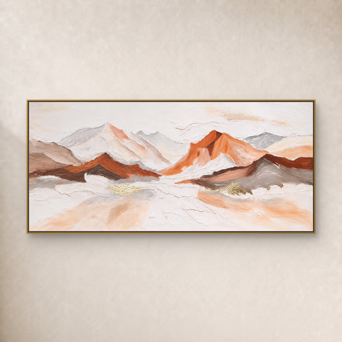 Copper-orange and ivory mountain panorama in a thin gold-tone floating frame on a warm ivory wall
