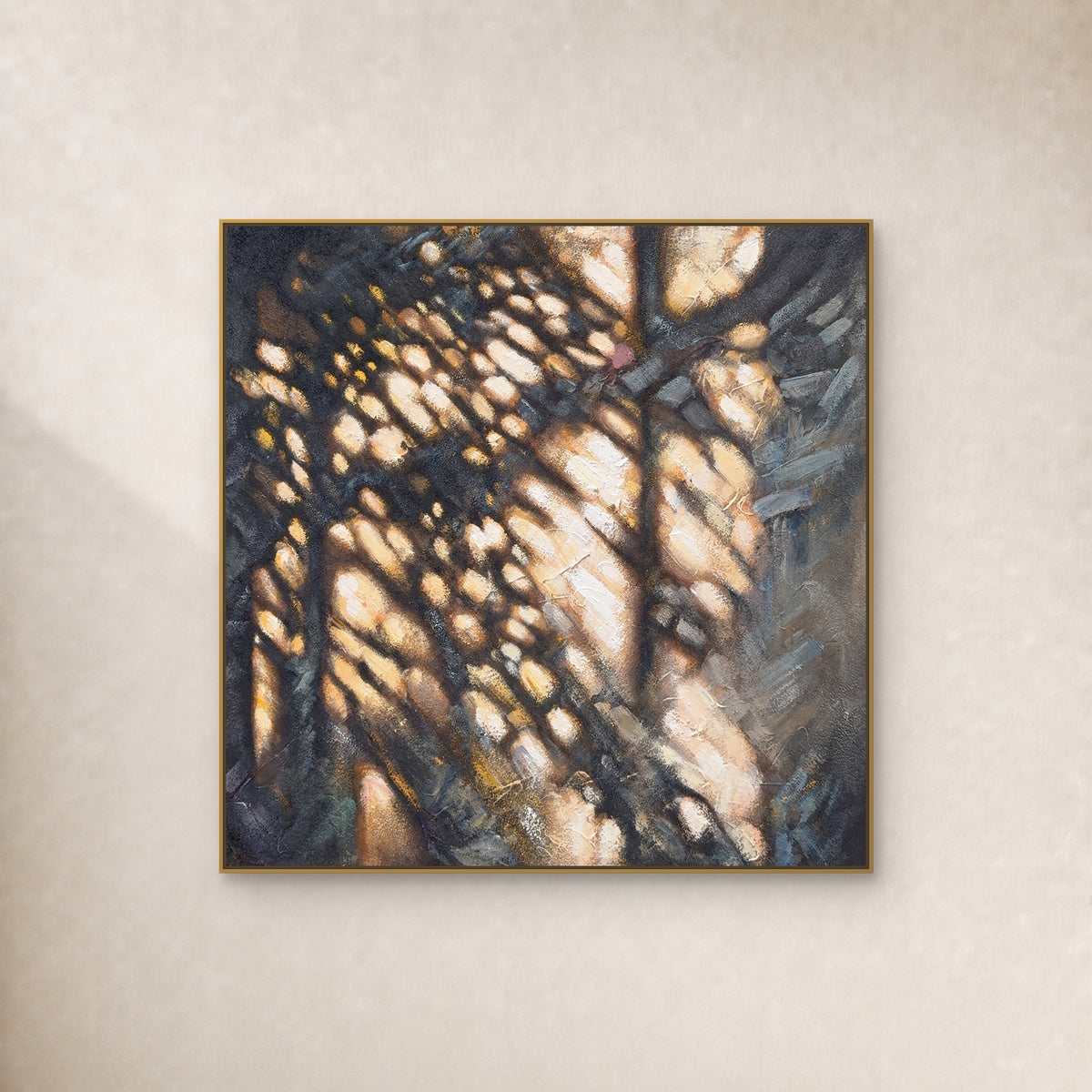 Tableau abstrait carré ocre et anthracite dans un fin cadre flottant doré sur un mur ivoire