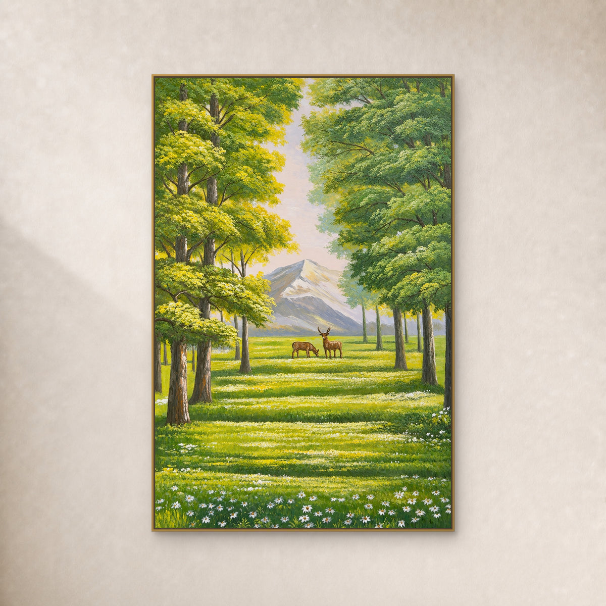 Two deer in a sunlit green grove with a distant mountain, in a slim gold floating frame on an ivory wall