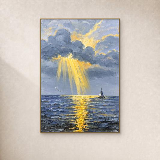 Rayons dorés perçant des nuages bleu-gris au-dessus de la mer et d’un petit voilier, dans un fin cadre doré sur un mur ivoire.