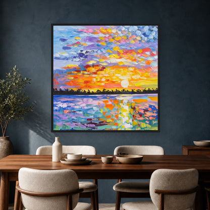 Colorful square sunset painting in a slim black floating frame above a dark wood dining table