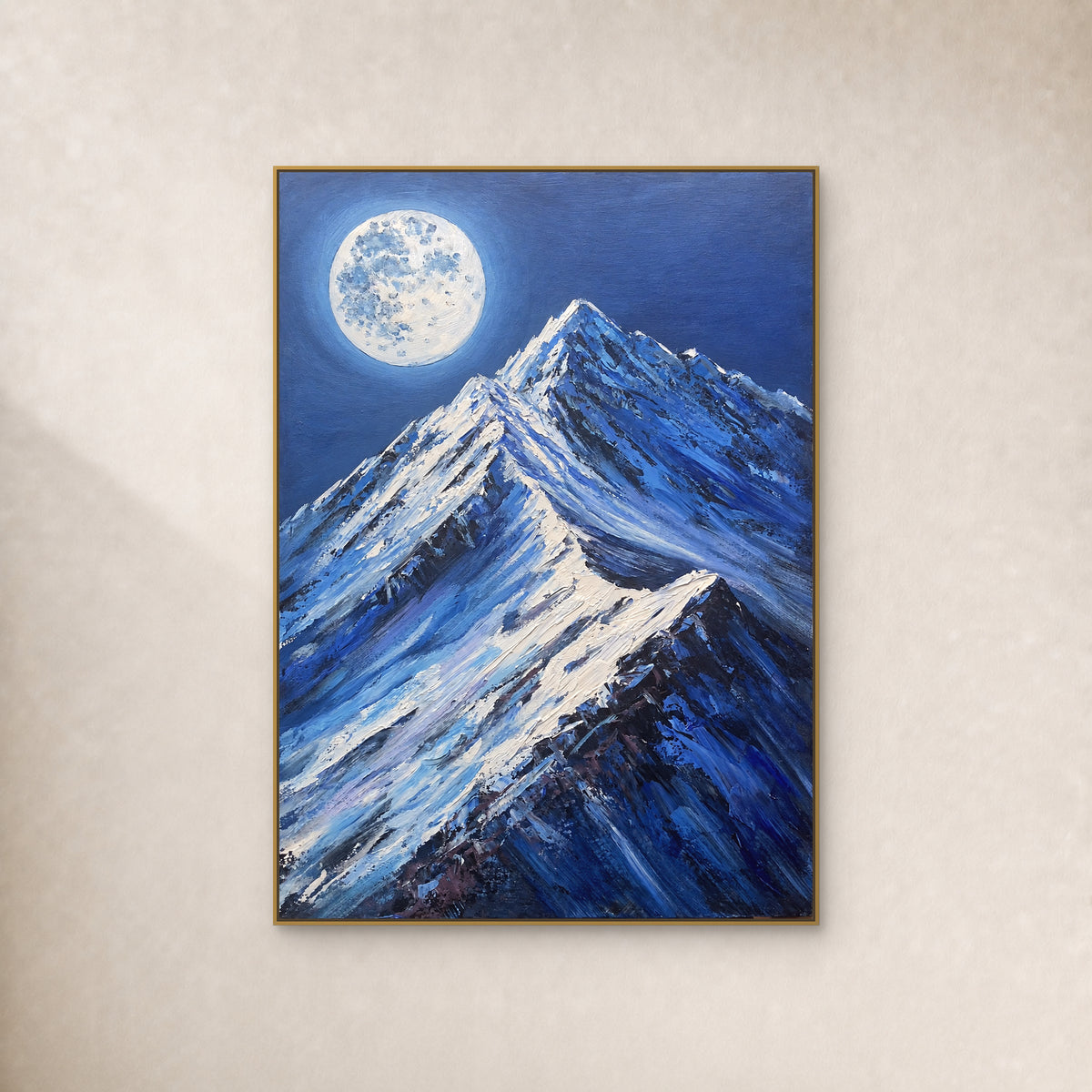 Pleine lune pâle au-dessus de sommets bleus enneigés, dans un fin cadre flottant doré sur un mur ivoire