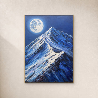 Pleine lune pâle au-dessus de sommets bleus enneigés, dans un fin cadre flottant doré sur un mur ivoire