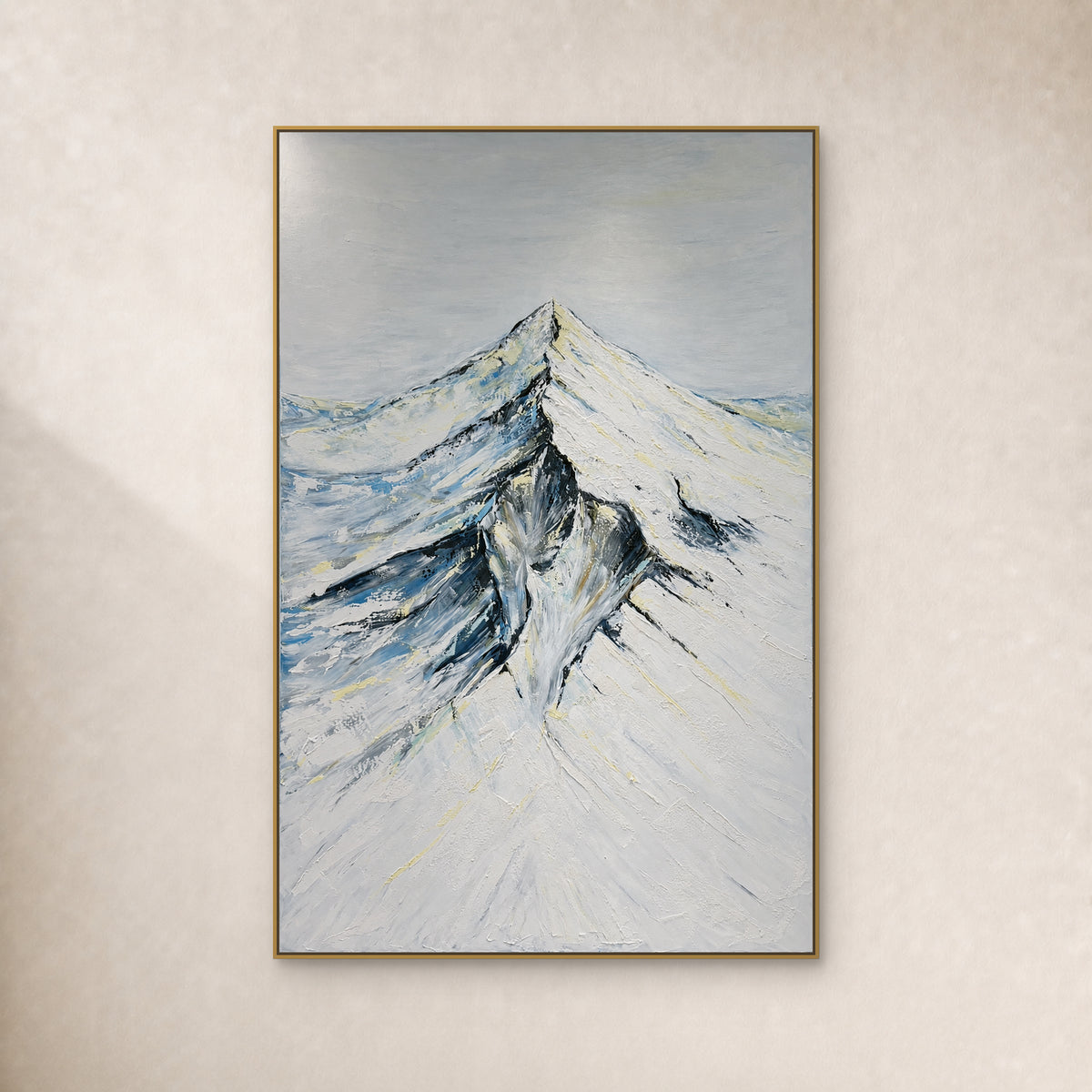 Crête enneigée, versants ivoire et ombres bleu-gris dans un cadre fin doré sur un mur ivoire