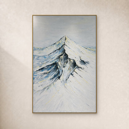 Crête enneigée, versants ivoire et ombres bleu-gris dans un cadre fin doré sur un mur ivoire