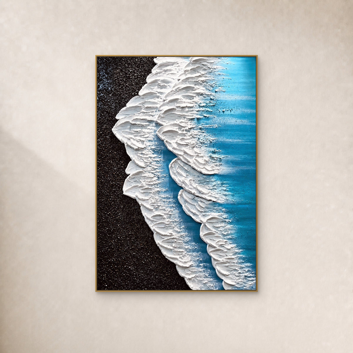 Écume blanche et eau turquoise près d’un rivage noir, dans un fin cadre doré sur un mur ivoire