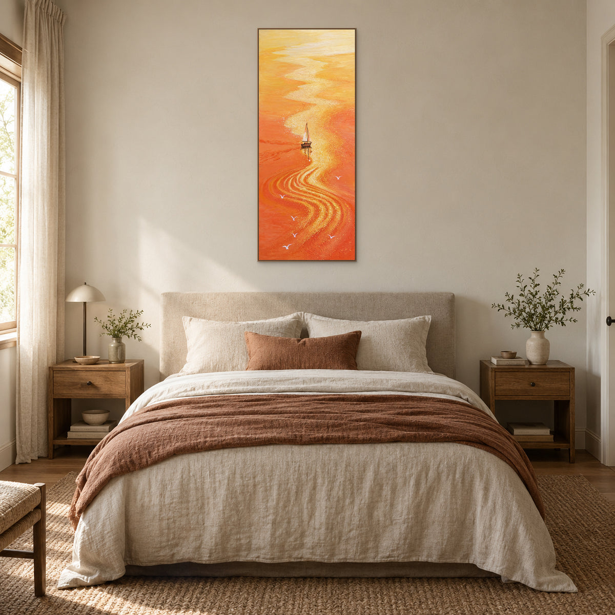 Tableau orange de voilier dans un cadre ton chêne, centré au-dessus d'un lit crème avec un plaid rouille