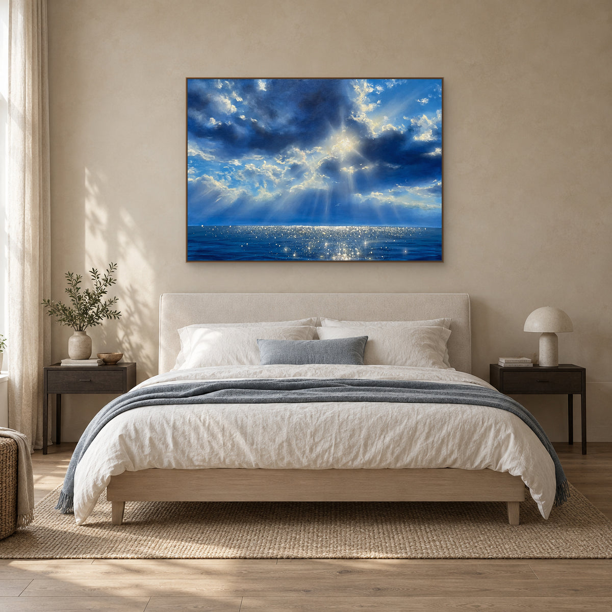 Rêverie bleue dans un fin cadre aspect chêne, centrée au-dessus d’une tête de lit crème rembourrée.