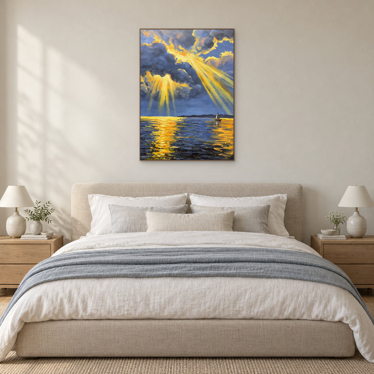 Tableau marin aux rayons dorés, dans un cadre flottant ton chêne, au-dessus d’un lit aux textiles bleu-gris.