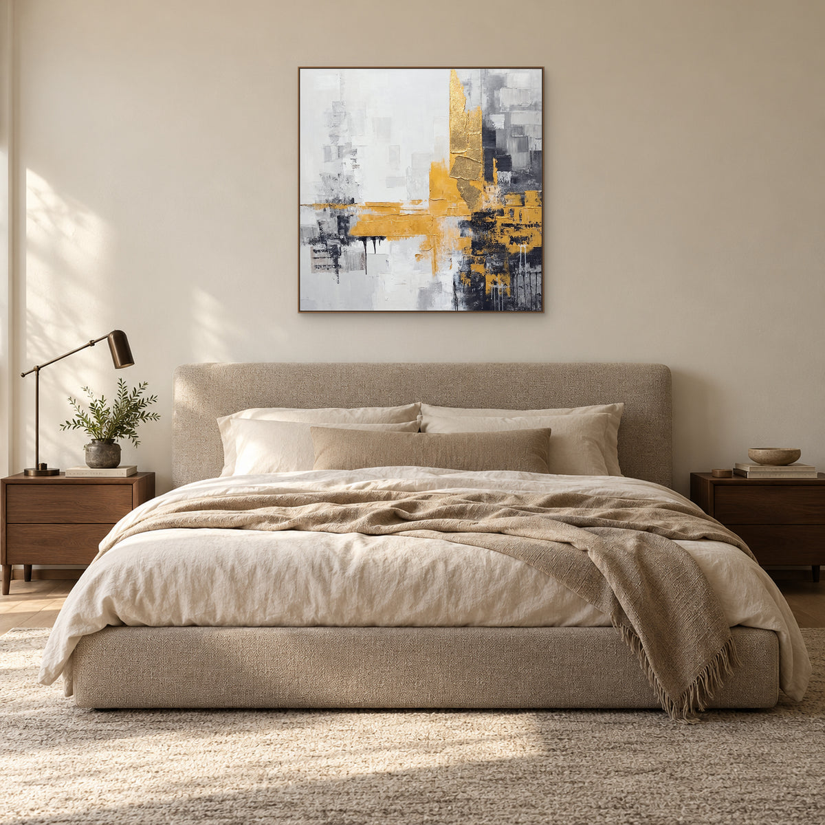 Tableau carré gris et doré dans un cadre ton chêne, centré au-dessus d’un lit tapissé écru