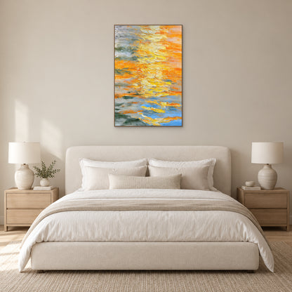 Yellow abstract painting in an oak-toned frame centred above a cream upholstered bed with matching bedside lamps
