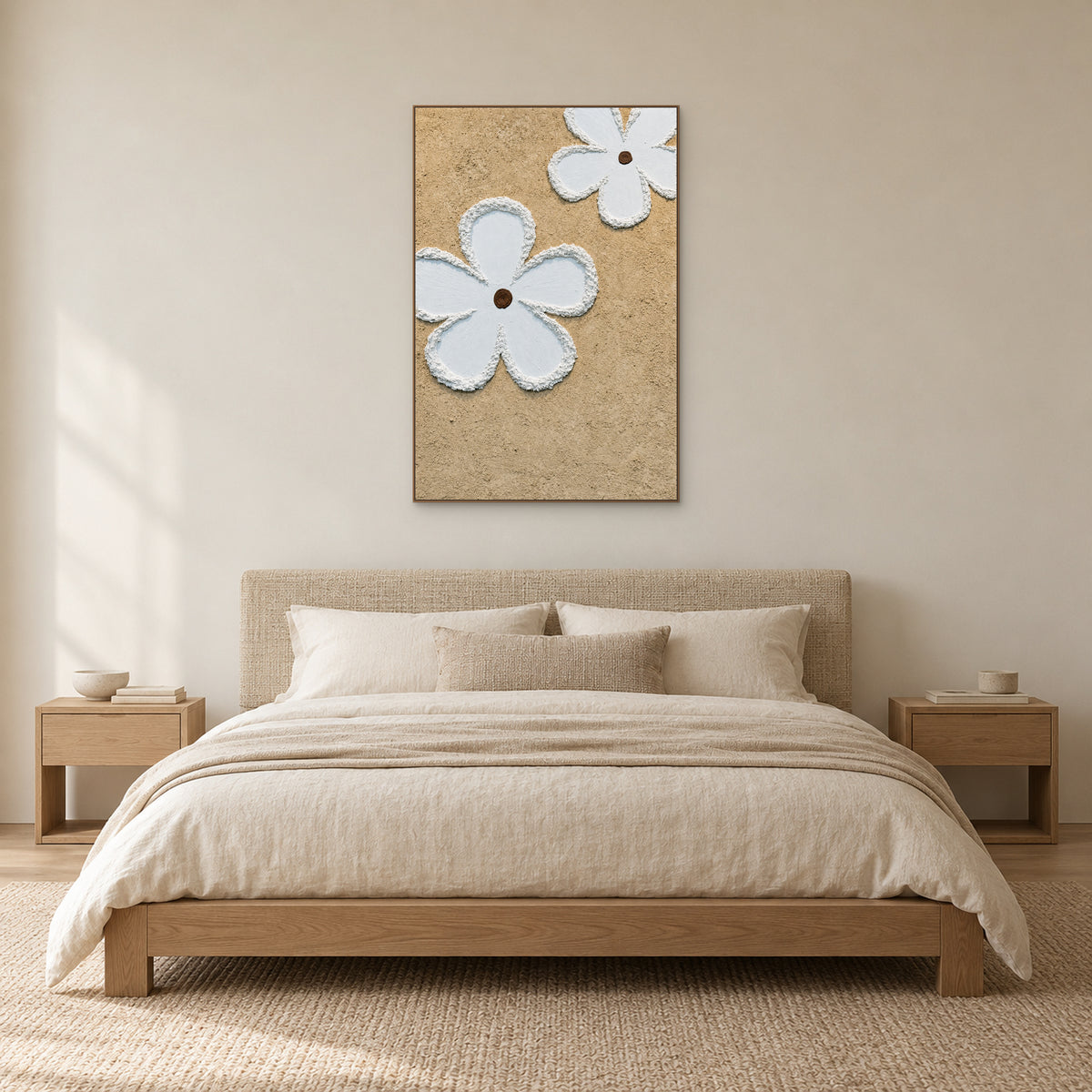 Fleurs blanches en relief dans un cadre ton chêne, au-dessus d’une tête de lit tissée et de linge crème
