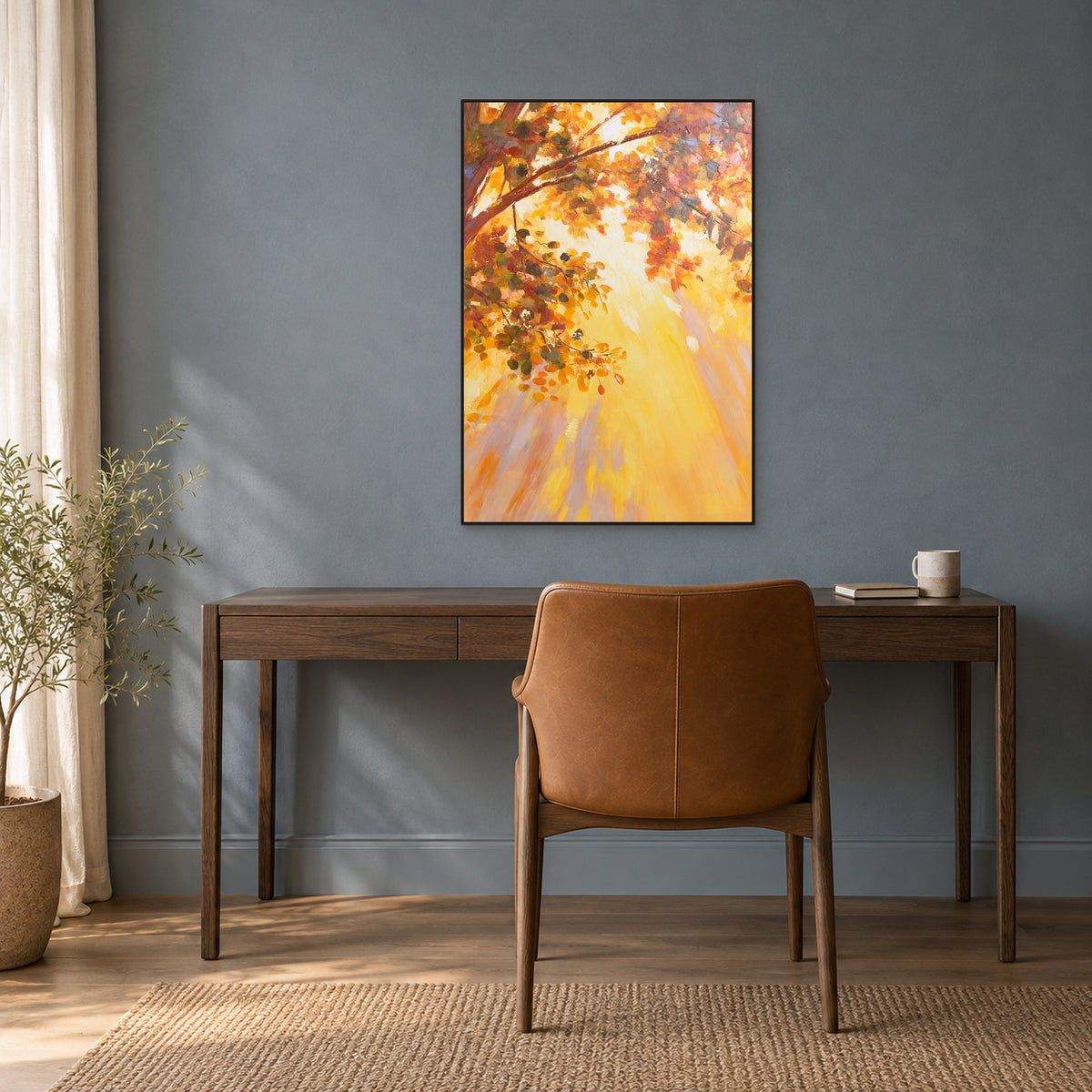 Tableau d’arbre automnal doré dans un fin cadre flottant noir, au-dessus d’un bureau en bois sombre contre un mur bleu-gris.