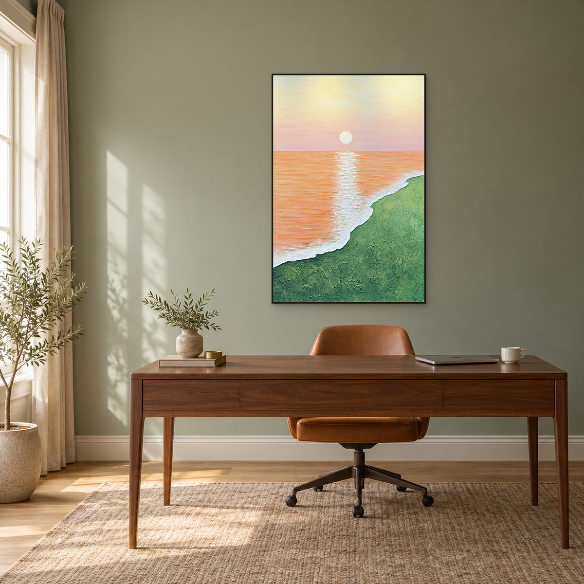 Tableau marin abricot vertical dans un cadre noir au-dessus d’un bureau en noyer et d’une chaise caramel, sur un mur sauge