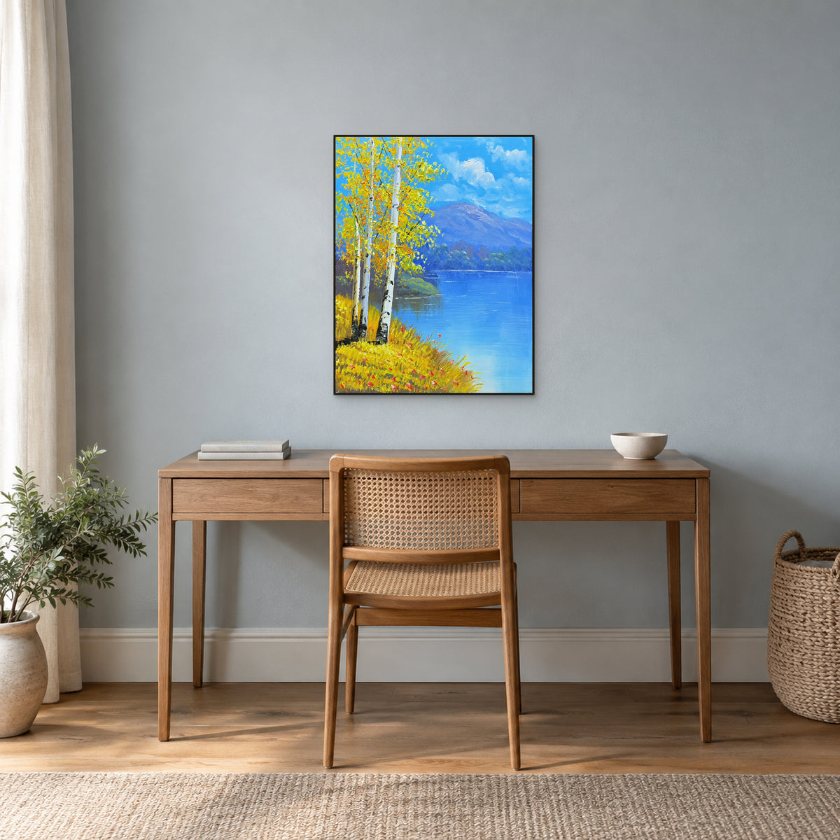 Bouleaux d’automne et lac bleu dégagé dans un fin cadre noir au-dessus d’un bureau en bois.