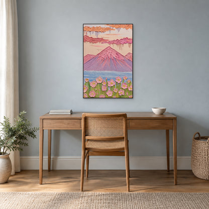 Paysage de montagne rose dans un fin cadre noir au-dessus d’un bureau en bois, sur un mur bleu-gris