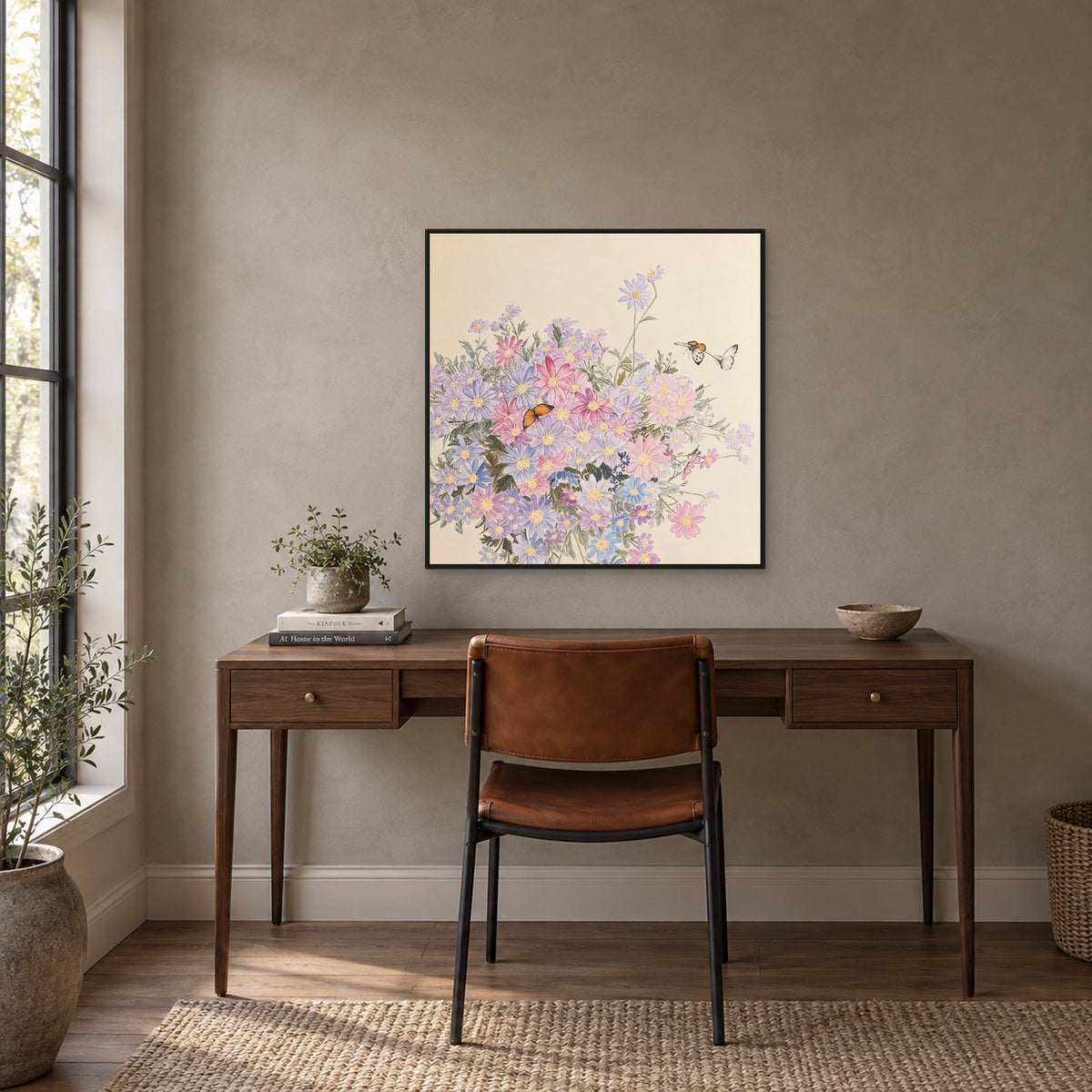 Square floral painting in a thin black floating frame centred above a writing desk