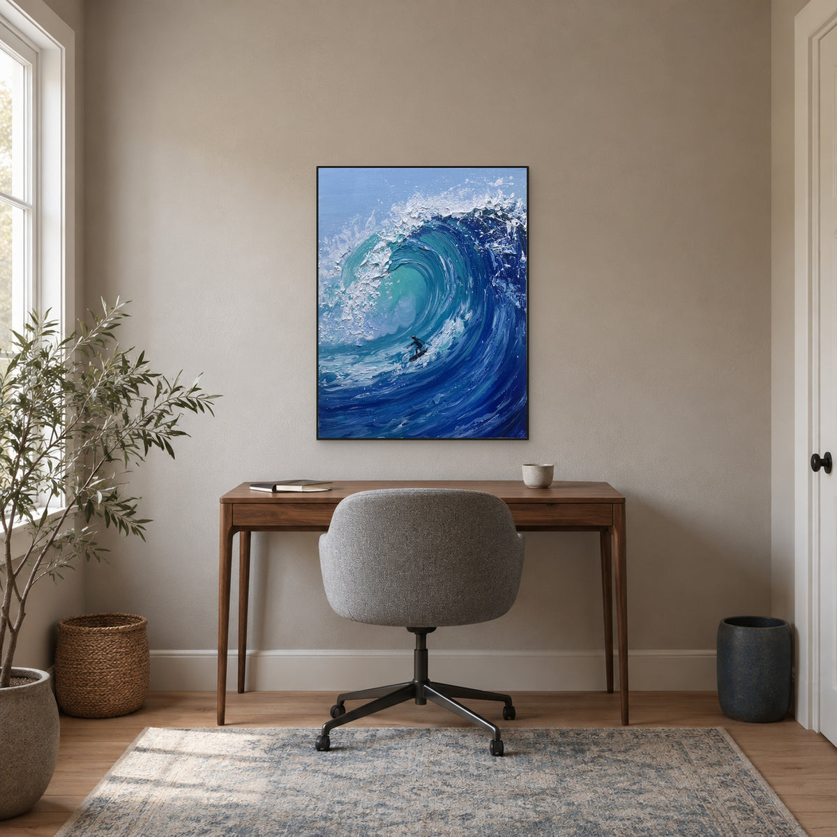 Tableau de surf turquoise dans un cadre noir, au-dessus d’un bureau en bois et d’une chaise grise