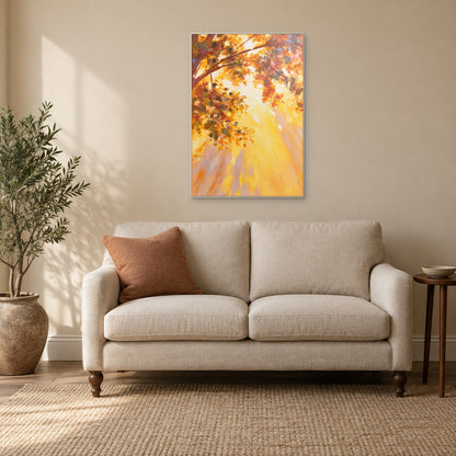 Tableau de feuillage automnal dans un fin cadre blanc, au-dessus d’un petit canapé crème avec un coussin terre cuite.