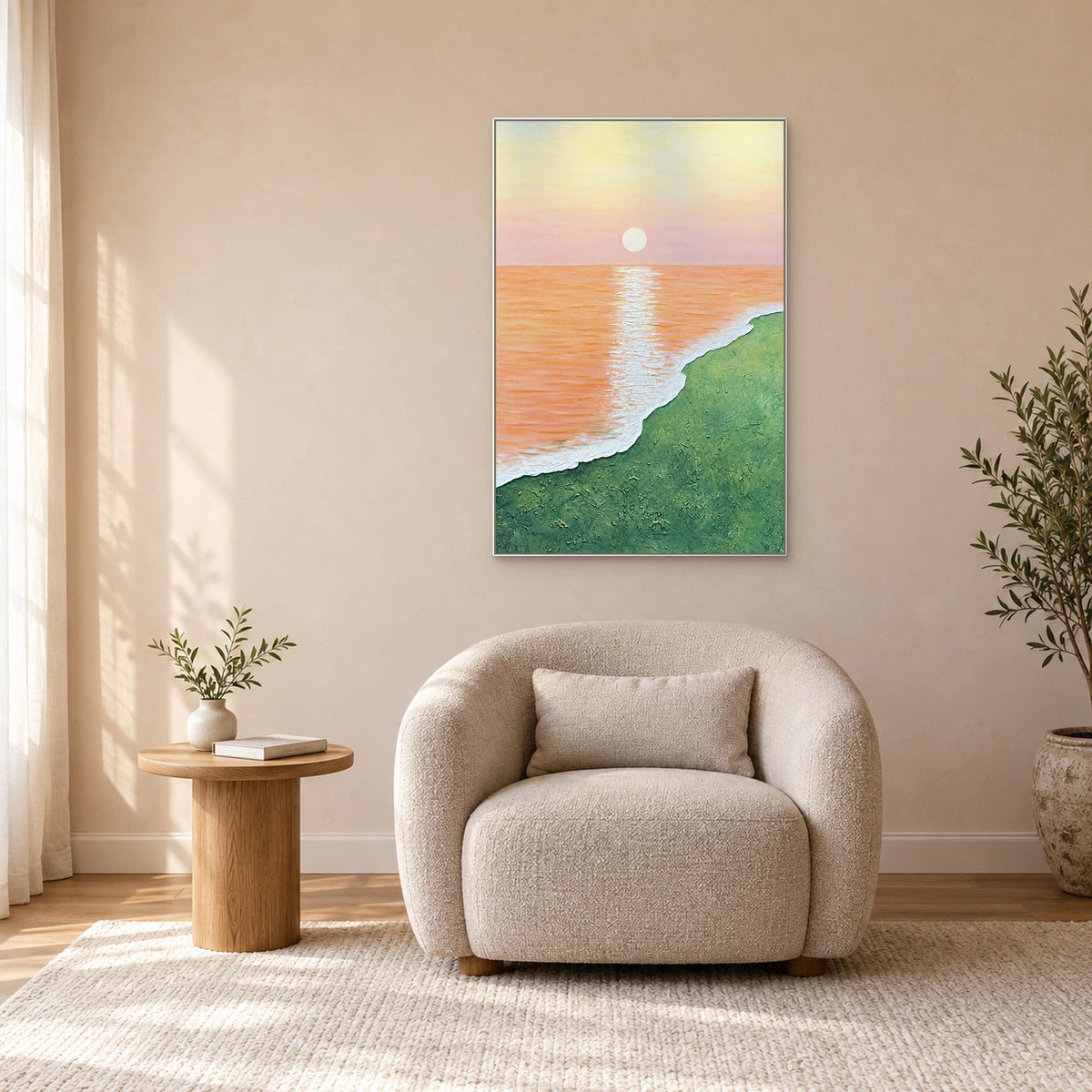 Tableau de rive verte dans un cadre blanc au-dessus d’un fauteuil écru, sur un mur pêche