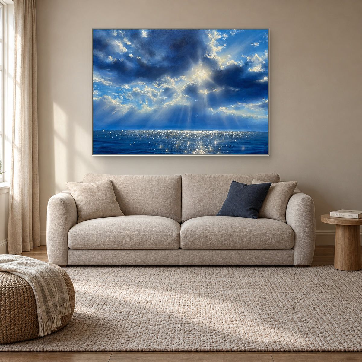 Tableau de nuages bleus et de rayons lumineux, dans un cadre flottant blanc au-dessus d’un petit canapé beige.
