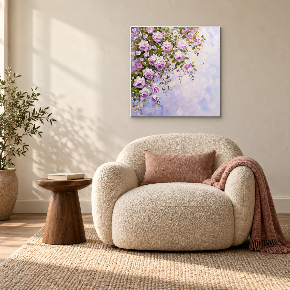 Tableau de roses en cascade dans un cadre blanc au-dessus d'un fauteuil crème près d'une fenêtre