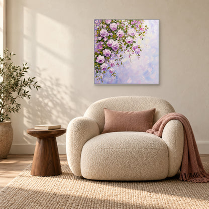 Tableau de roses en cascade dans un cadre blanc au-dessus d'un fauteuil crème près d'une fenêtre