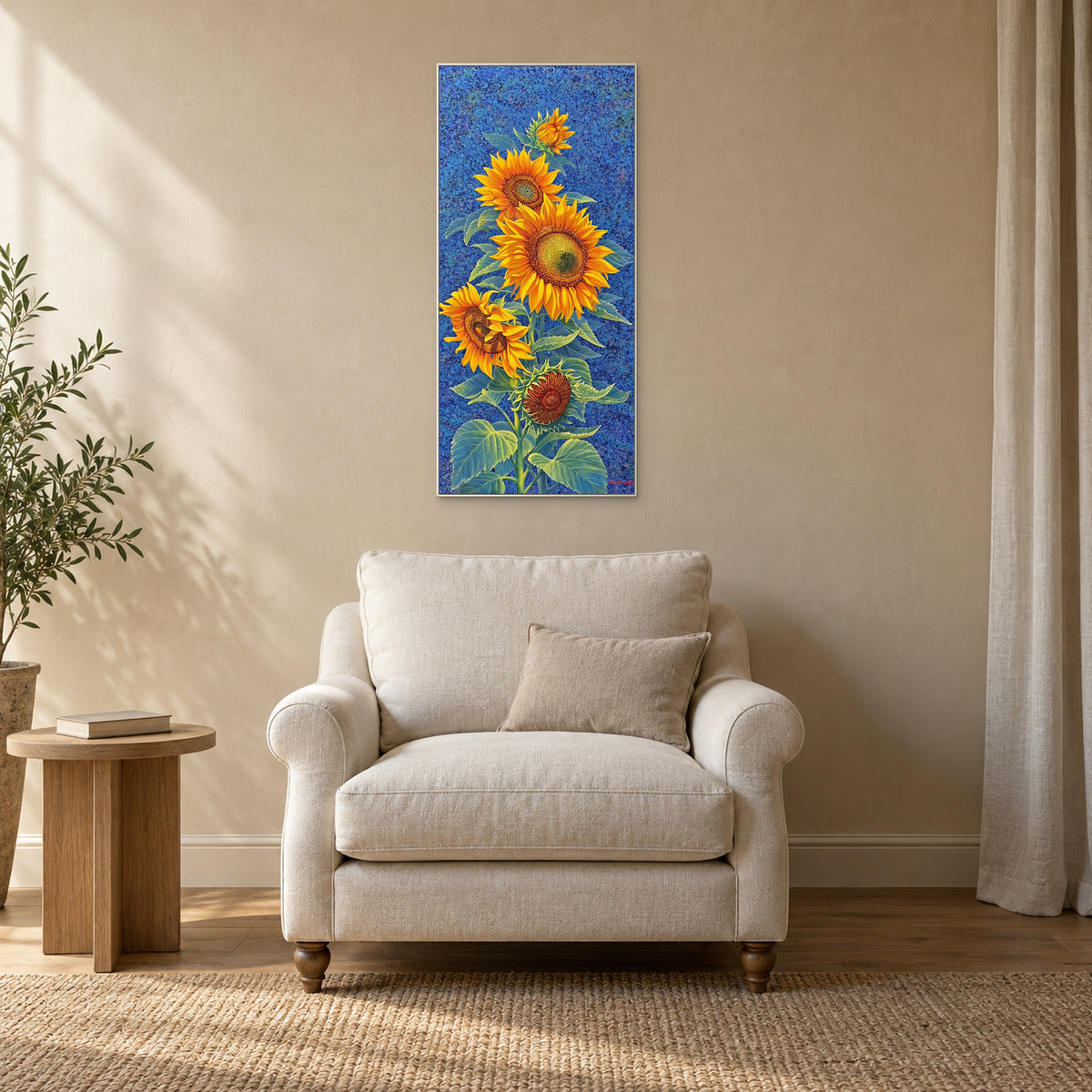 Tournesols dans un cadre blanc au-dessus d’un fauteuil crème, à côté d’une petite table en bois