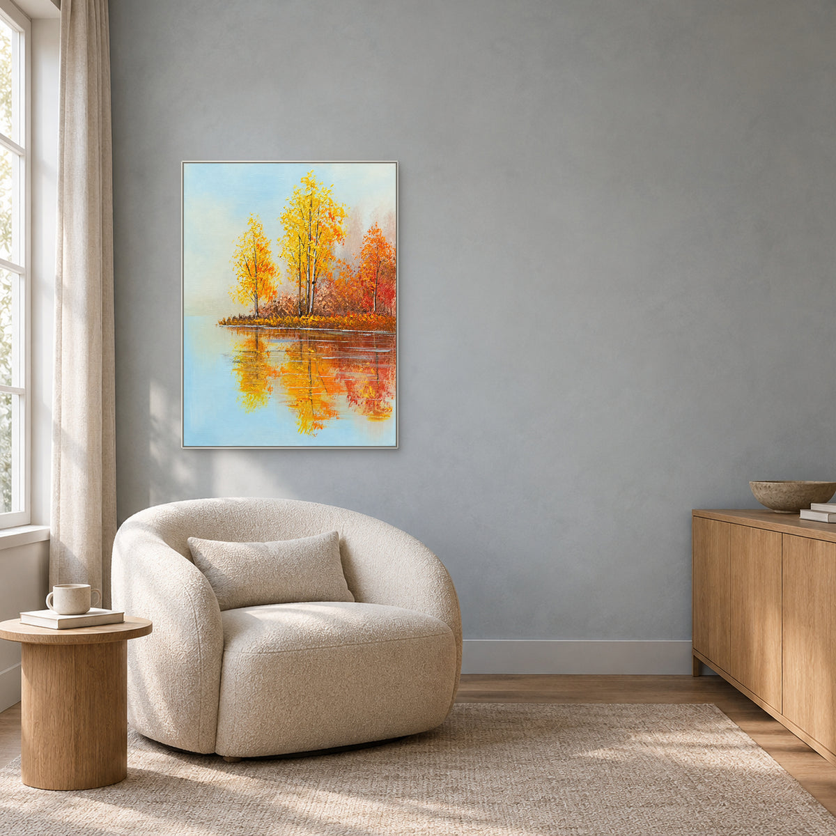Reflets de bouleaux d’automne dans un cadre blanc au-dessus d’un fauteuil de lecture crème arrondi, sur un mur gris