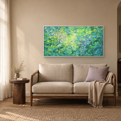 Floraison verte dans un cadre flottant blanc, au-dessus d’un petit canapé beige à accoudoirs en bois, avec coussin lilas et table ronde