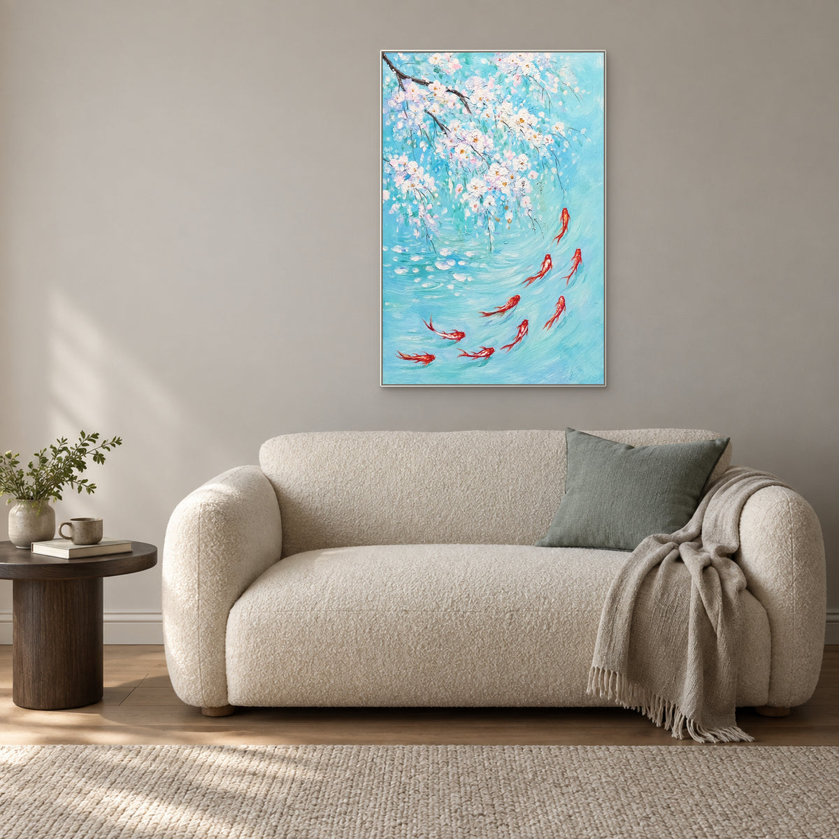 Fleurs blanches et carpes rouges sur turquoise dans un cadre flottant blanc, au-dessus d’un petit canapé bouclé crème au coussin vert d’eau.