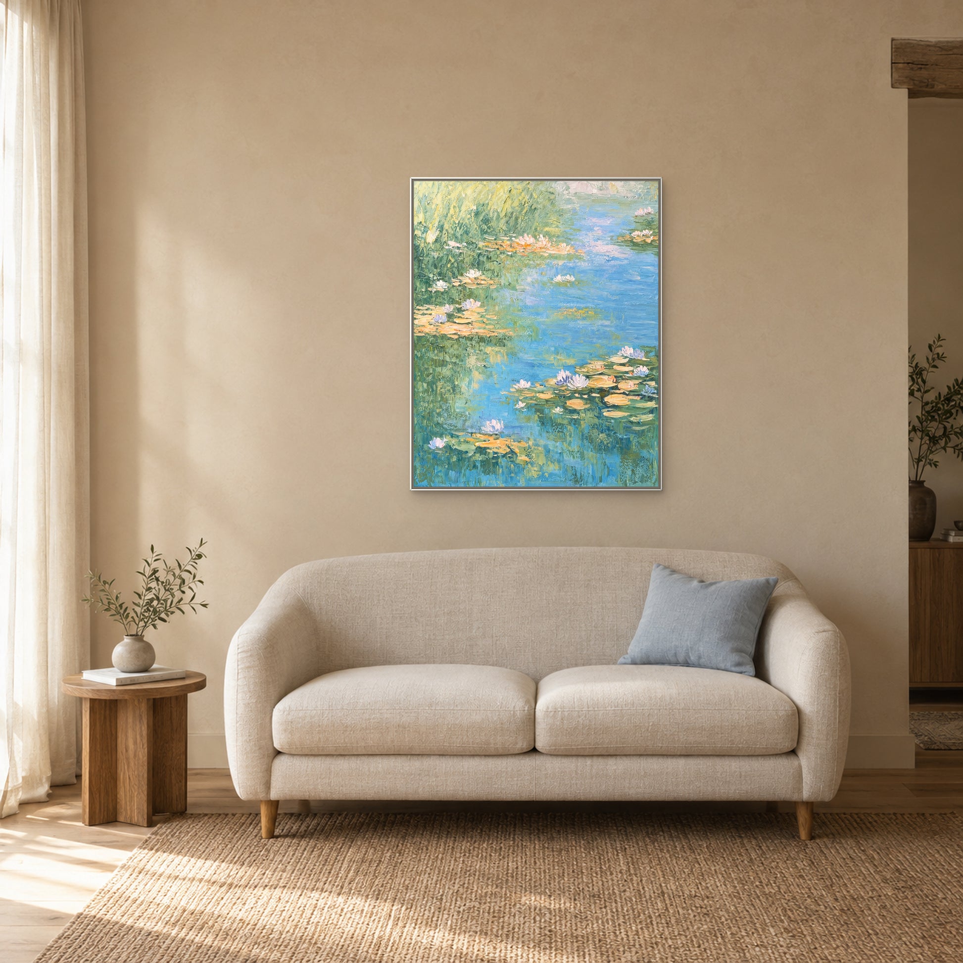 Tableau de nénuphars pastel dans une caisse américaine blanche au-dessus d’une banquette crème au coussin bleu
