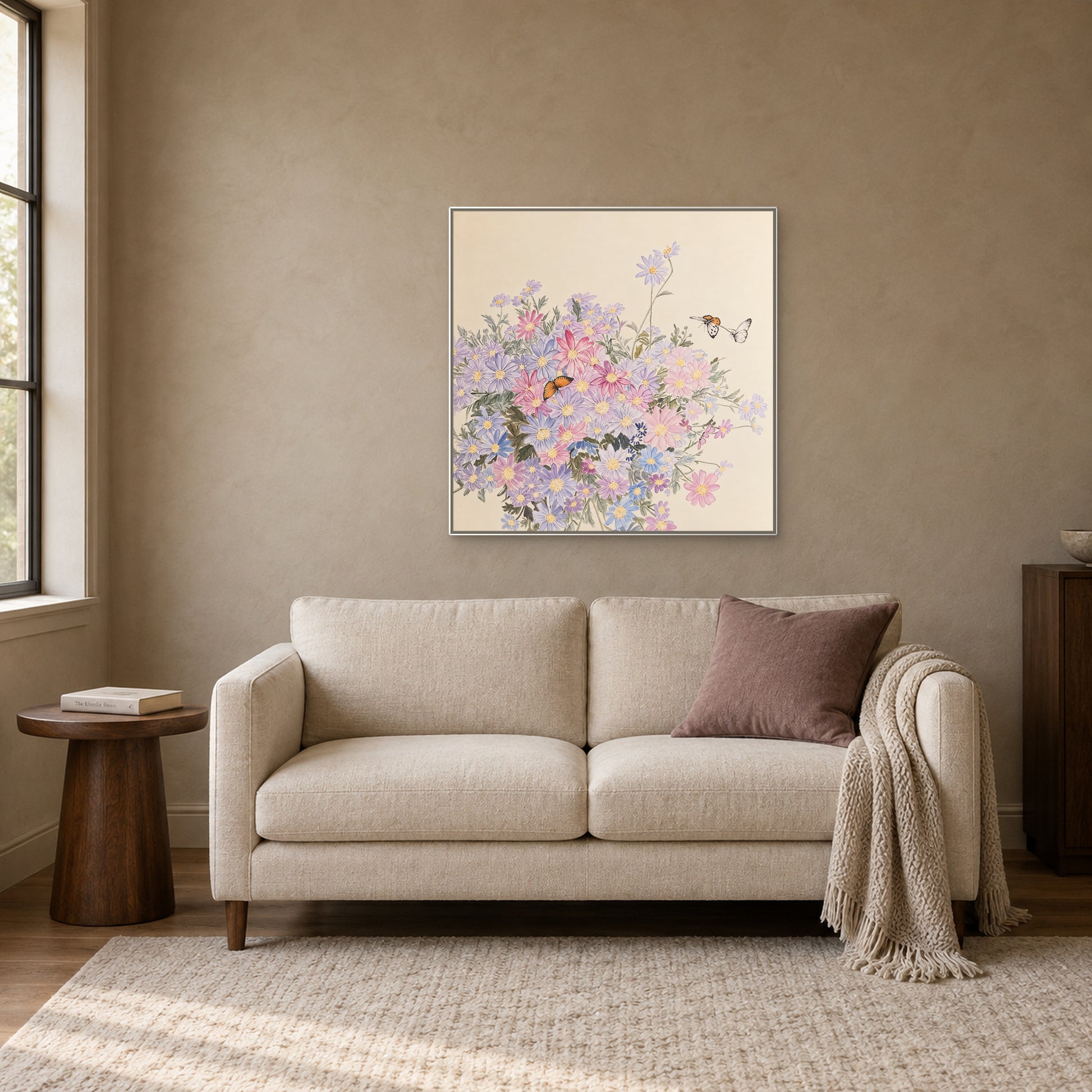 Wildflower and butterfly artwork in a white floating frame above a cream loveseat