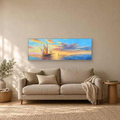 Sunset sailing scene in a white frame above a taupe loveseat in a reading nook