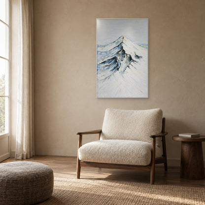 Montagne ivoire et bleu-gris dans un cadre blanc au-dessus d'un fauteuil de lecture texturé