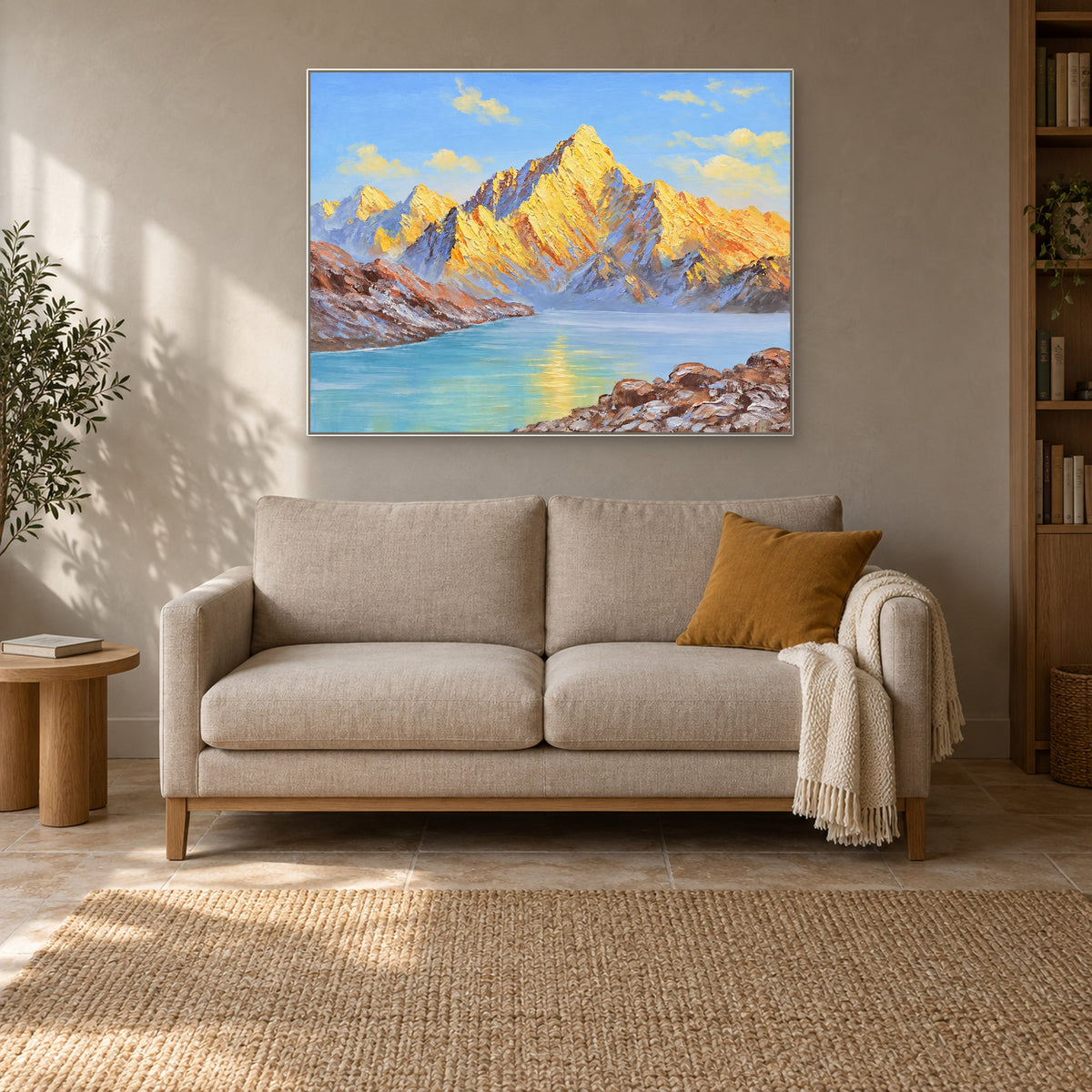 White-framed mountain lake landscape above a cream loveseat with an ochre cushion