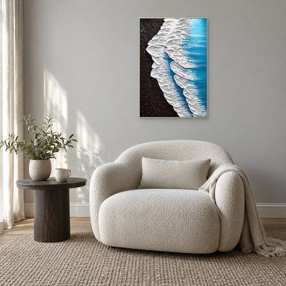 Tableau de vagues blanches en relief, encadré de blanc au-dessus d’un fauteuil crème arrondi