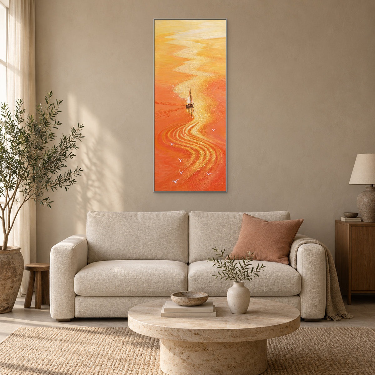 Mer orange et reflet doré dans un cadre argenté, au-dessus d'un canapé crème avec un coussin corail doux