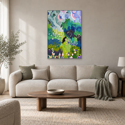 Blue-green foliage and black cat painting in a silver-toned floating frame above a pale sofa and oval wood coffee table