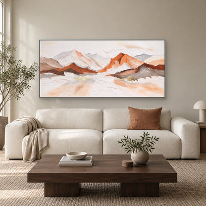 Copper-lit mountain panorama in a silver-tone floating frame above a cream sofa and walnut coffee table