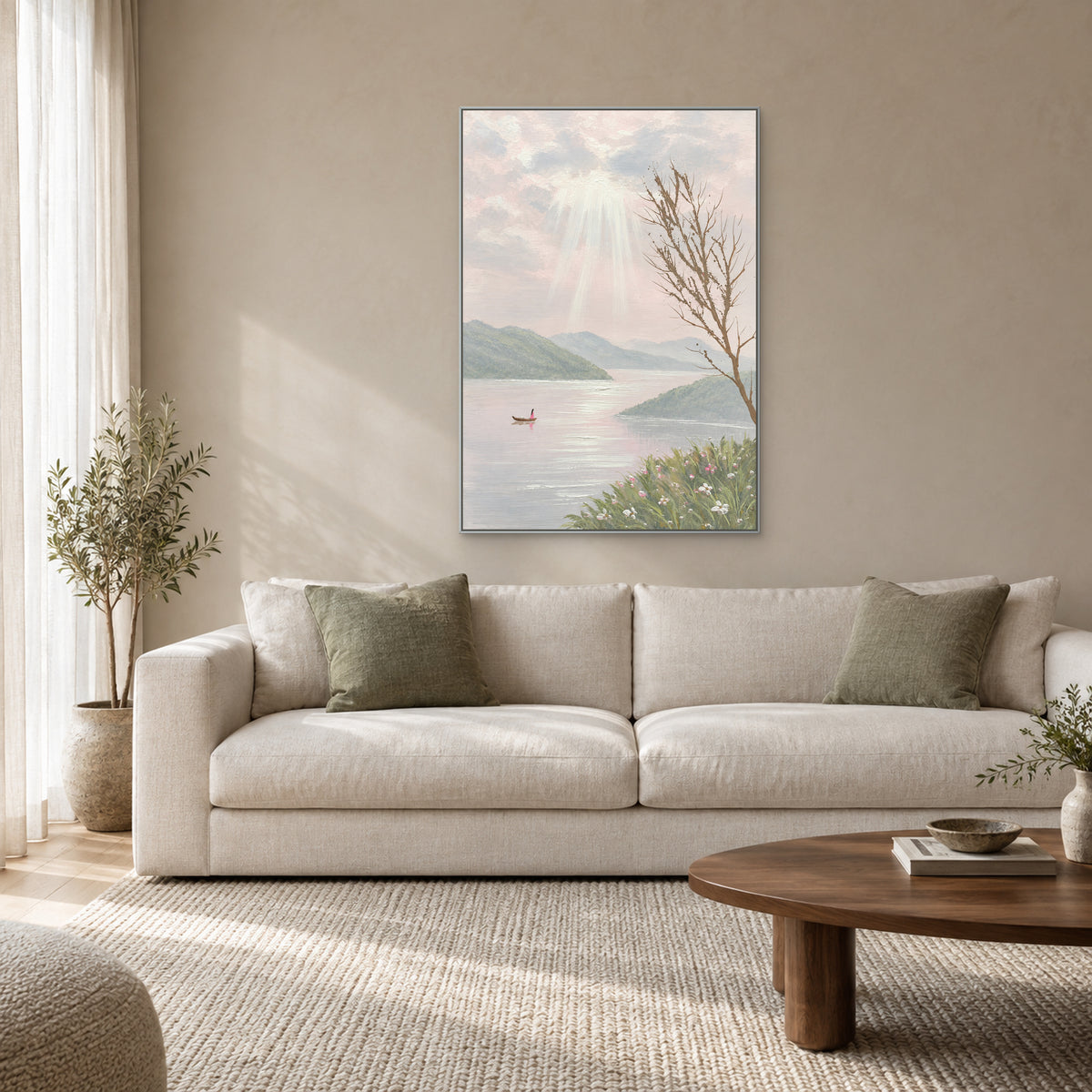 Vertical lake and mountain artwork in a silver-tone frame above a light fabric sofa