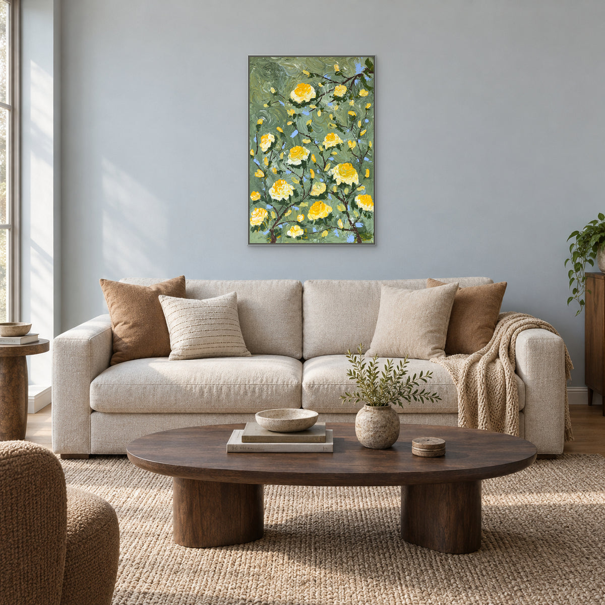 Vertical rose painting in a silver-tone floating frame above an oatmeal sofa on a pale blue-grey wall