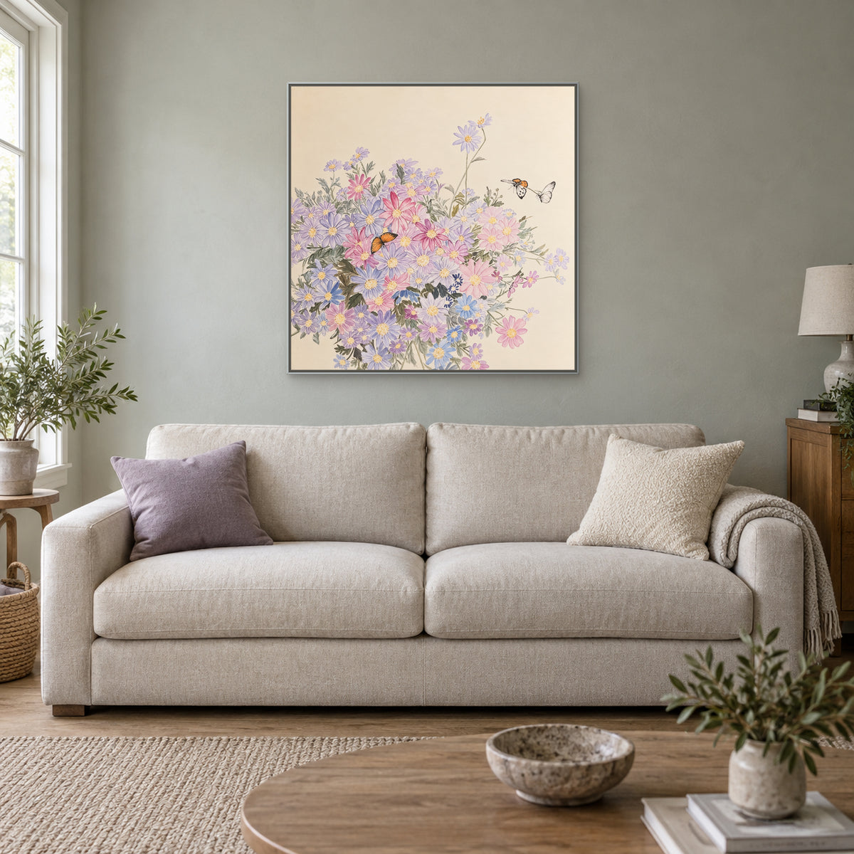 Pastel square floral artwork in a silver-look floating frame above an oatmeal sofa
