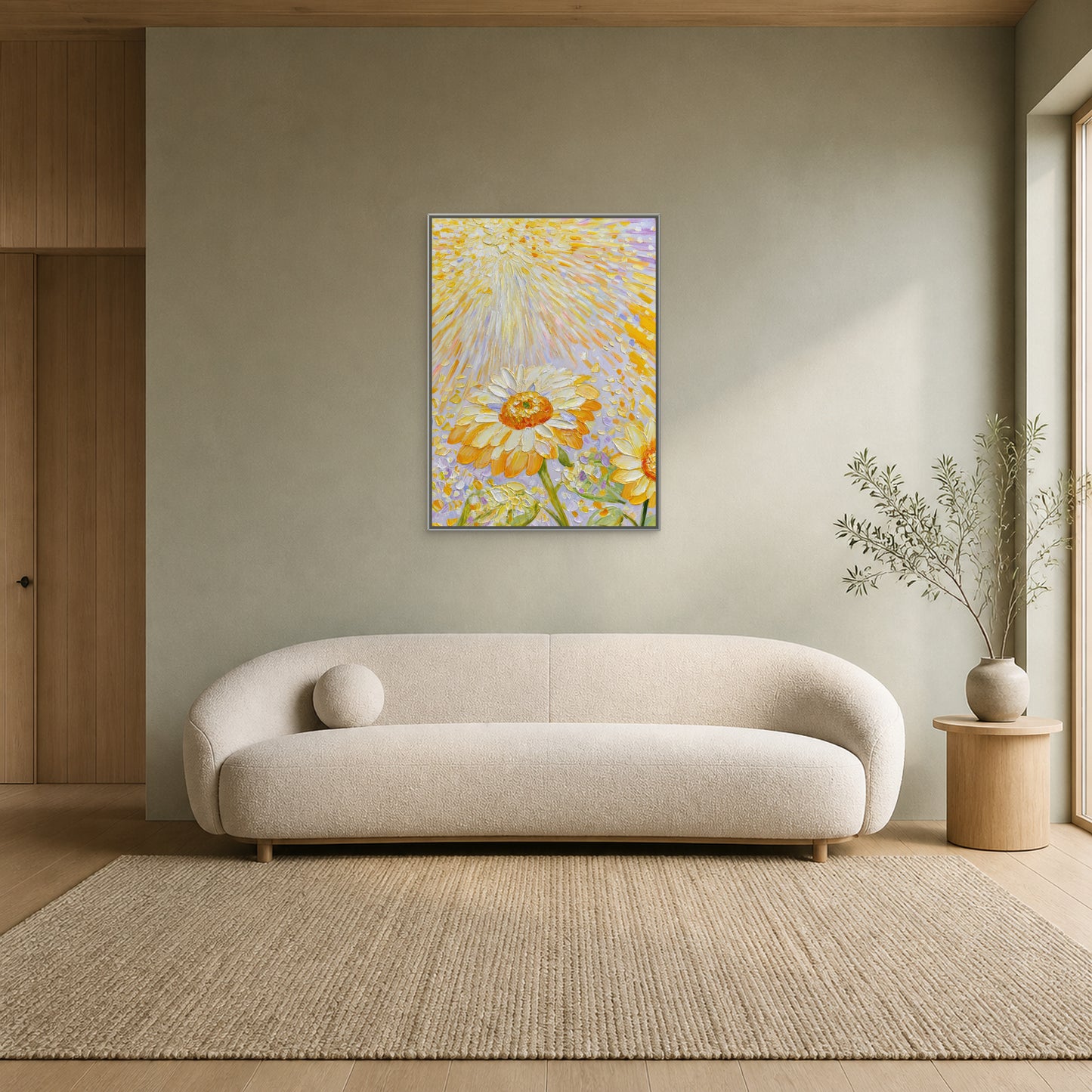 Tournesols dans la lumière dorée dans un fin cadre flottant argenté centré au-dessus d’un canapé crème incurvé sur un mur sauge pâle