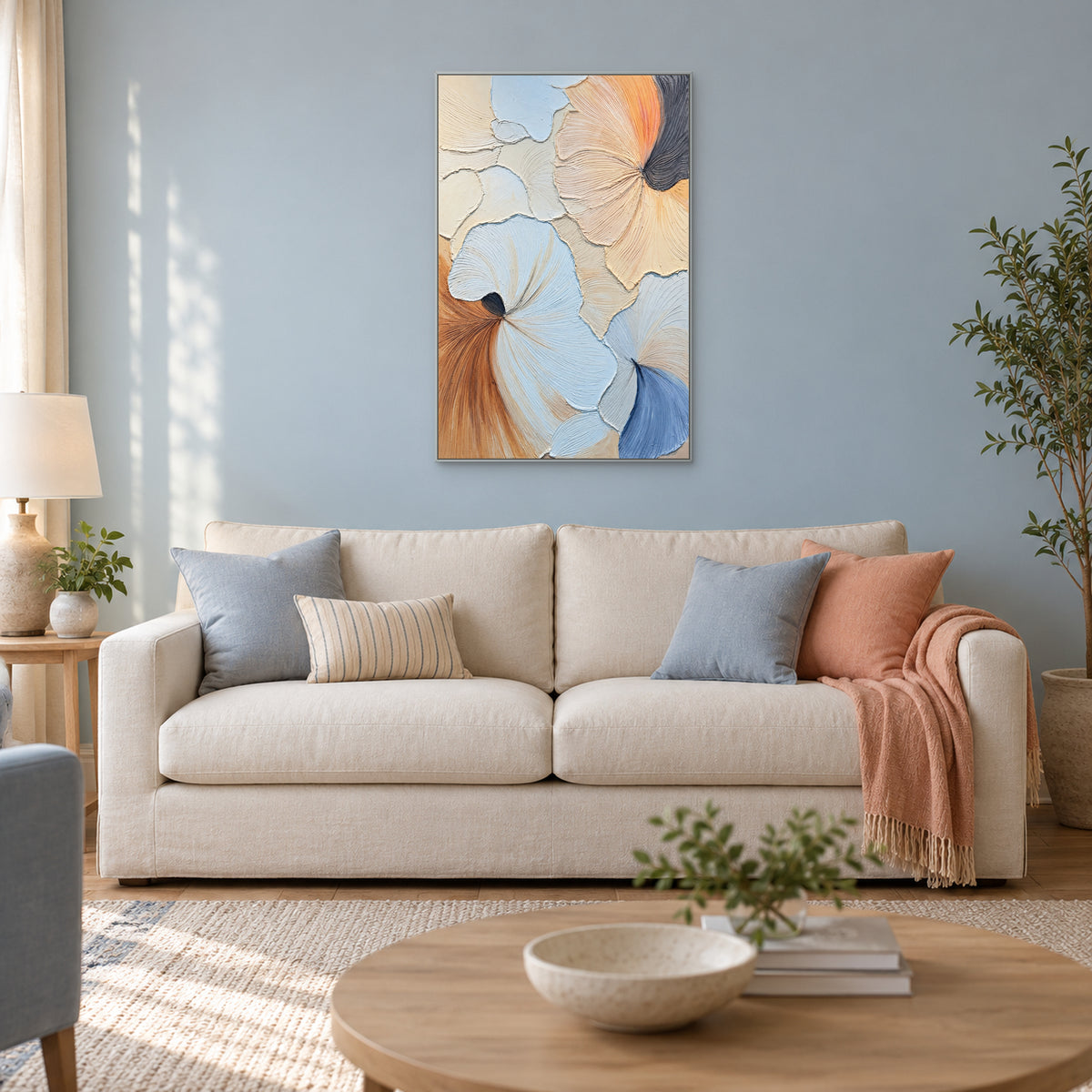 Abstrait pastel en éventails, cadre argenté sur mur bleu-gris, au-dessus d’un canapé ivoire aux accents bleus et pêche