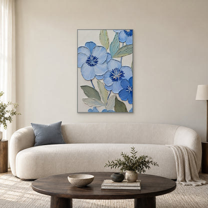 Tableau floral bleu en relief dans un cadre fin argenté, centré au-dessus d'un canapé crème aux lignes arrondies