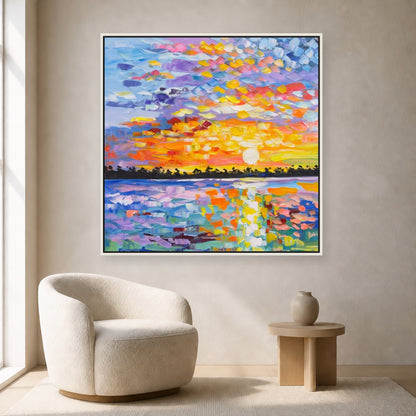 Colorful square sunset painting in a slim white floating frame above an ivory reading chair