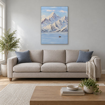 Tableau vertical de montagnes enneigées dans un cadre flottant argenté, centré au-dessus d’un canapé aux tons neutres